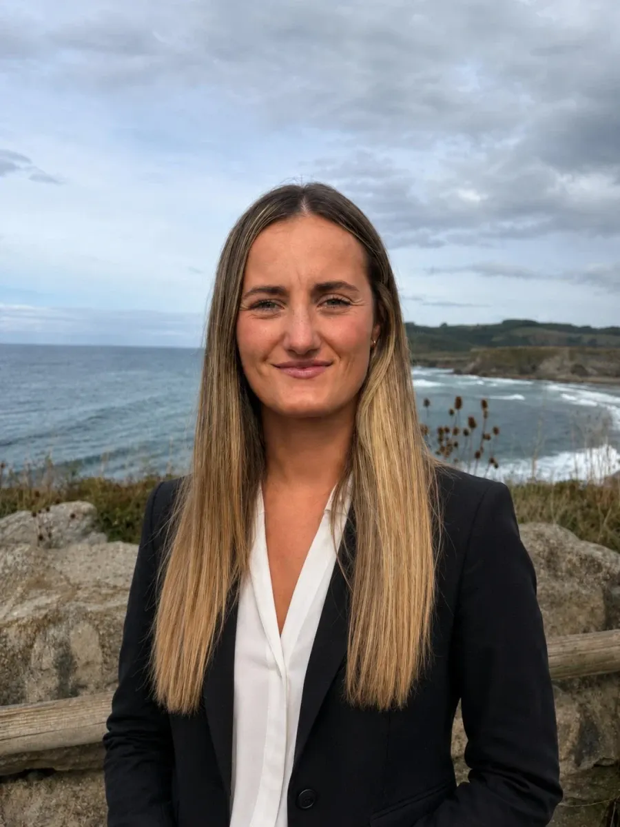 Paula Lavín, asesora fiscal, con americana oscura y el mar al fondo