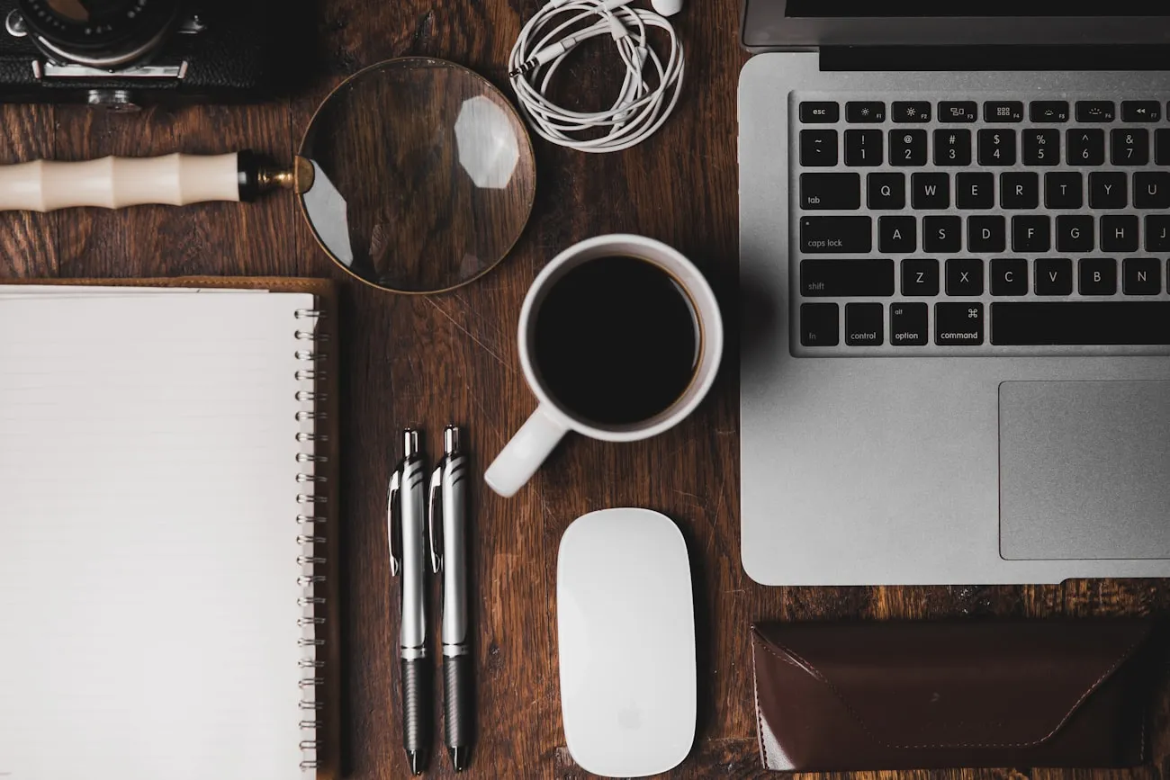 Escritorio de trabajo con portátil, cuaderno y café